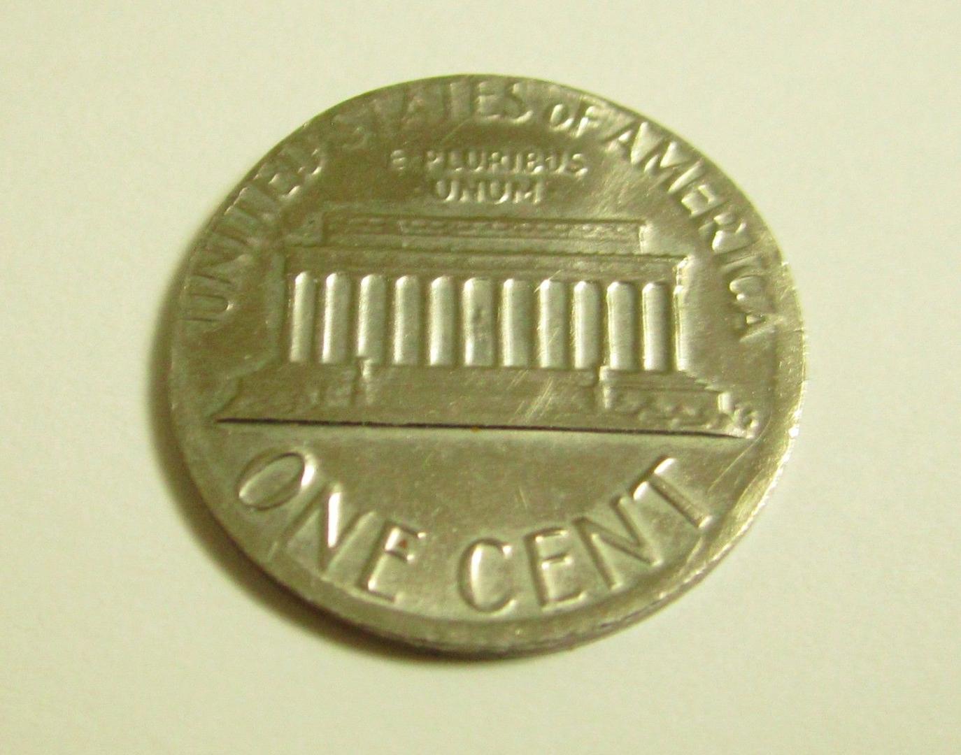 1980 penny struck on Roosevelt dime planchet showing silver-white color and smaller 17.9mm diameter compared to normal copper penny